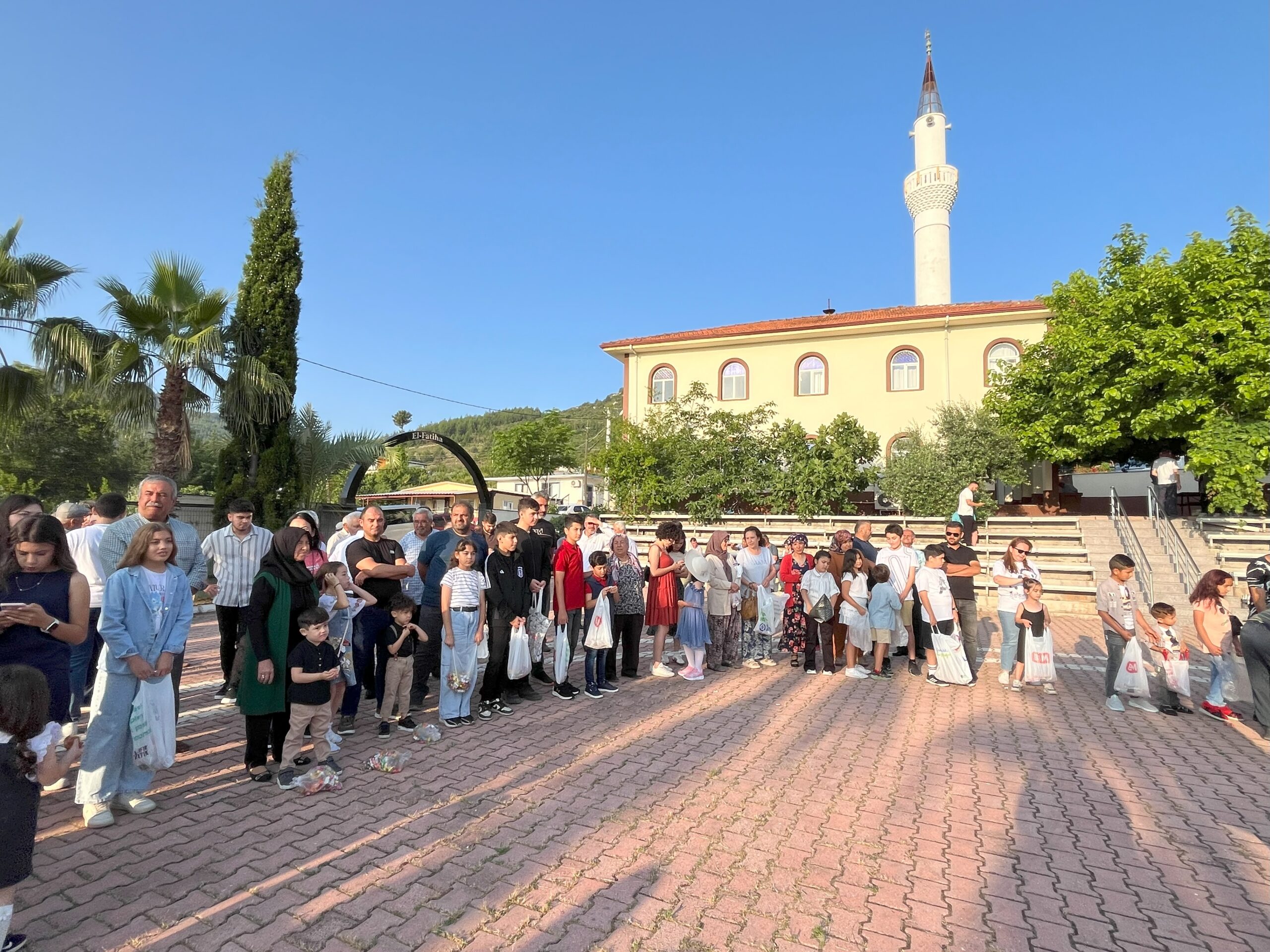 kalpgazetesi.com-Antalya'da yıllardır aynı geleneği yaşatan mahalle sakinleri cami avlusundaki çocuklara şeker dağıttı